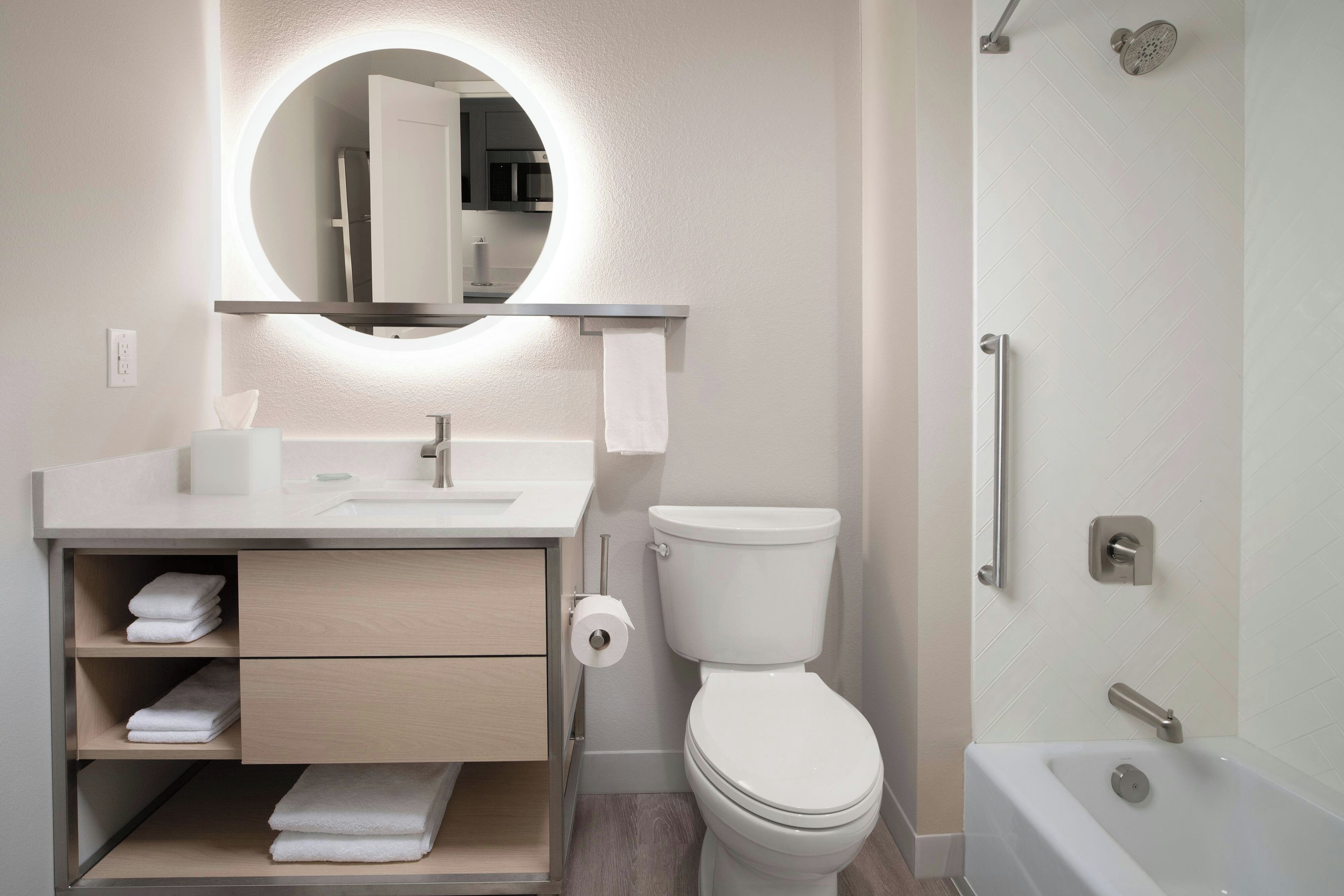 A modern bathroom with a toilet, sink, and bathtub.