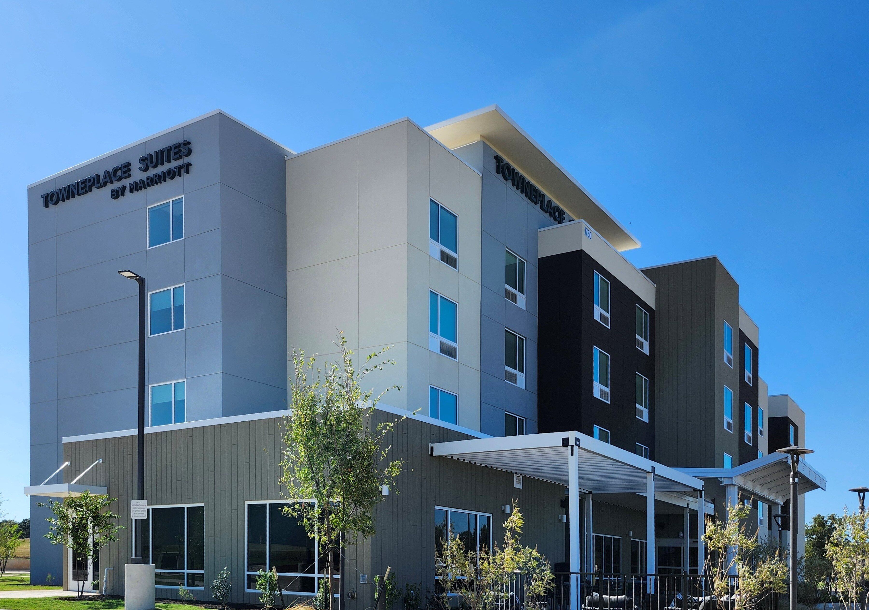 A multi-story hotel with a modern design, featuring a prominent sign for 'Towneplace Suites by Marriott'.