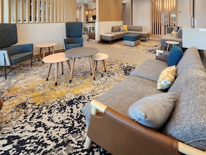 A modern lounge area with sofas, chairs, and a coffee table. - Towneplace Suites By Marriott Burnet (Burnet)