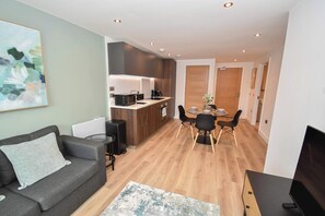 A compact living space with a kitchenette, dining area, and seating. - Bright & Contemporary 1 Bedroom Apartment in Leeds (Leeds)
