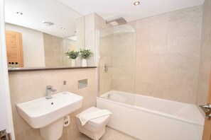 A modern bathroom with a glass-enclosed shower, a white sink, and a toilet. - Bright & Contemporary 1 Bedroom Apartment in Leeds (Leeds)