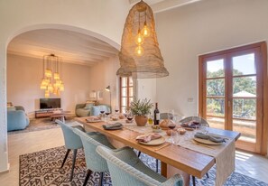 Un coin repas avec une table en bois dressée pour le repas, entourée de chaises en osier.