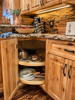 Una cocina con armarios de madera, protector contra salpicaduras de piedra y estufa integrada.