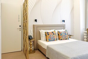 A hotel room with a bed, a bedside table, a telephone, and a decorative wall panel. - Hotel 77 Lisbon (Lisbon)