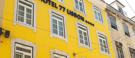 Un edificio amarillo con el cartel 'HOTEL 77 LUSSON' que indica que es un hotel.