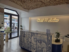 A hotel reception desk with a large illuminated sign reading 'Hotel 77 Lisbon.' - Hotel 77 Lisbon (Lisbon)