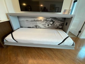 A bed with a white mattress and black trim, positioned under a flat-screen TV. - Orlando | Romantic Riviera Retreat | Pool + Resort (Lake Buena Vista)