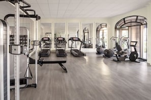 A gym with treadmills, elliptical machines, and weightlifting equipment. - Orlando | Romantic Riviera Retreat | Pool + Resort (Lake Buena Vista)