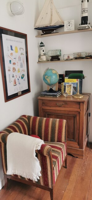 A cozy room with a striped armchair, a globe, and maritime-themed decorations. - Villa with sea view and private heated pool in the Crozon Peninsula (Finistère) (Landévennec)