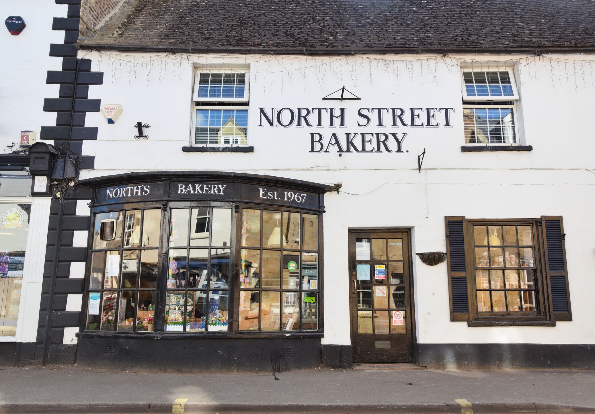 Een wit gebouw met zwarte details en een bord waarop staat: “North Street Bakery.”
