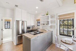 Una cocina moderna con electrodomésticos de acero inoxidable, una isla central y un ventanal.