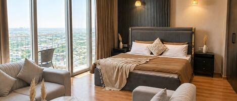 Un dormitorio moderno con una cama grande, un sofá y vistas a la ciudad.