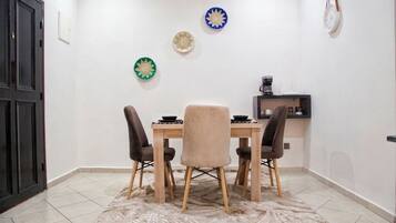 Een eetgedeelte met een tafel, vier stoelen en decoratieve borden aan de muur.