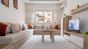 Una sala de estar moderna con un sofá, una mesa de centro y una televisión.