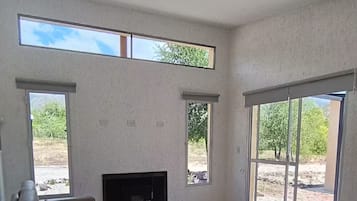 Een ruime woonkamer met een bank, een televisie en een eettafel met stoelen.