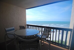 Ein Balkon mit Blick auf Strand und Meer.