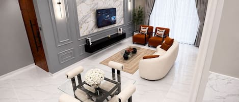 A modern living room with a marble wall, a flat-screen TV, a glass coffee table, and a sofa.