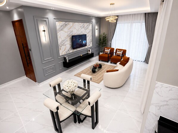 Una sala de estar moderna con una pared de mármol, un televisor de pantalla plana, una mesa de centro de vidrio y un sofá.