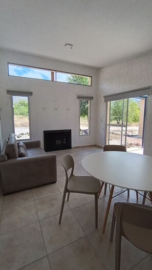Un grand espace de vie comprenant un canapé, un téléviseur et une table à manger avec des chaises.