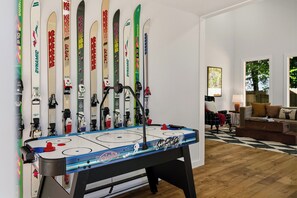 Ein Zimmer mit einem Kicker, einer Couch und Skiern an der Wand.