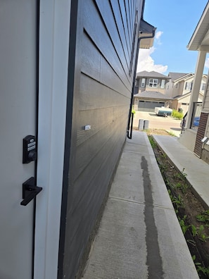A residential building with a grey exterior, a driveway, and a clear sky. - Imperial Lodge:3BD Peaceful Getaway Suite+King Bed (Edmonton)