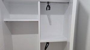 A walk-in closet with white walls and a wooden floor. - Imperial Lodge:3BD Peaceful Getaway Suite+King Bed (Edmonton)