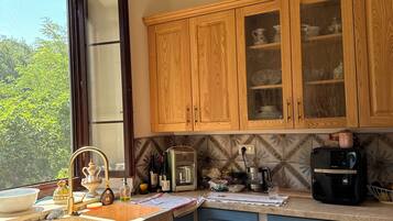 Una cucina con mobili in legno, un piano di lavoro e una finestra.