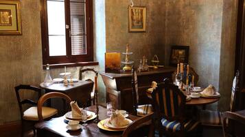 Una sala da pranzo con arredi in legno, un lampadario e opere d'arte incorniciate alle pareti.