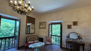A room with a chandelier, a sofa, a table, and a piano. - Palazzo degli Angeli Palace of Angels (Fivizzano)