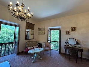 Una habitación con una araña, un sofá, una mesa y un piano.