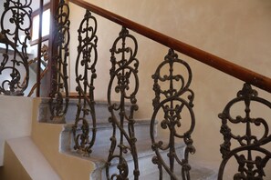 A staircase with ornate metal railings and a wooden handrail.