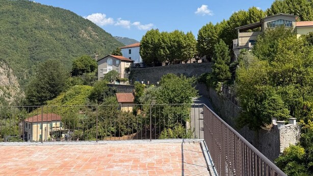 A hillside residential area with houses, a paved terrace, and a stone wall. - Palazzo degli Angeli Palace of Angels (Fivizzano)