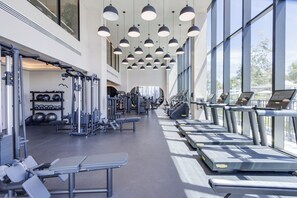 A gym with treadmills, weight machines, and exercise balls. - Luxury 4-bedroom condo At 72 Park With Gym, Pool, Tiki bar and Beach Service (Miami Beach)