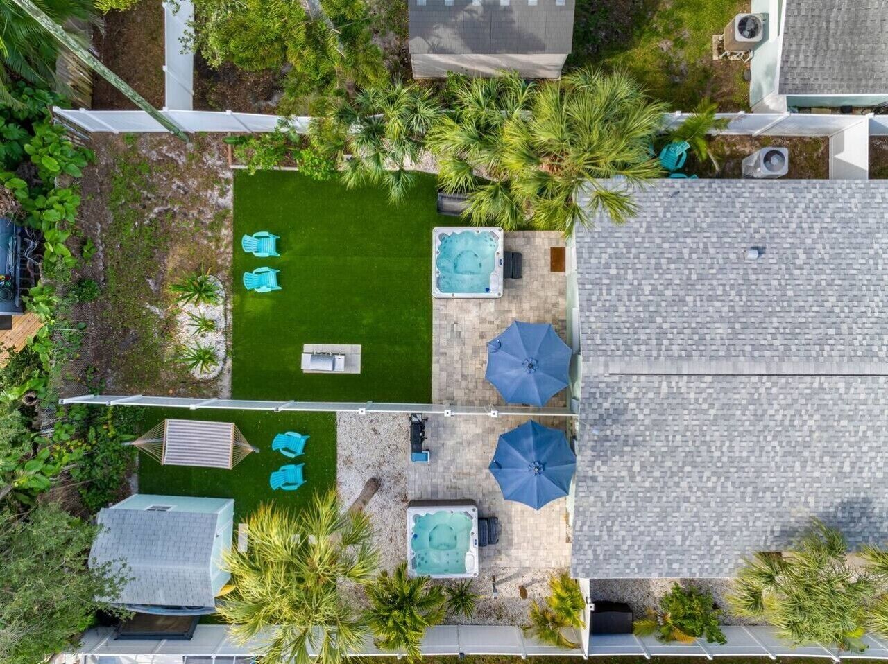 Een terras op het dak met een jacuzzi, parasols en zitgedeeltes.