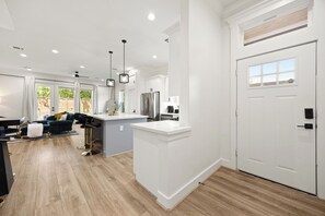 A modern kitchen with white cabinetry, a stainless steel refrigerator, and a white countertop. - The Suite Spot: 4BR with 2 King Suites and Private Patio near NRG Stadium (Houston)