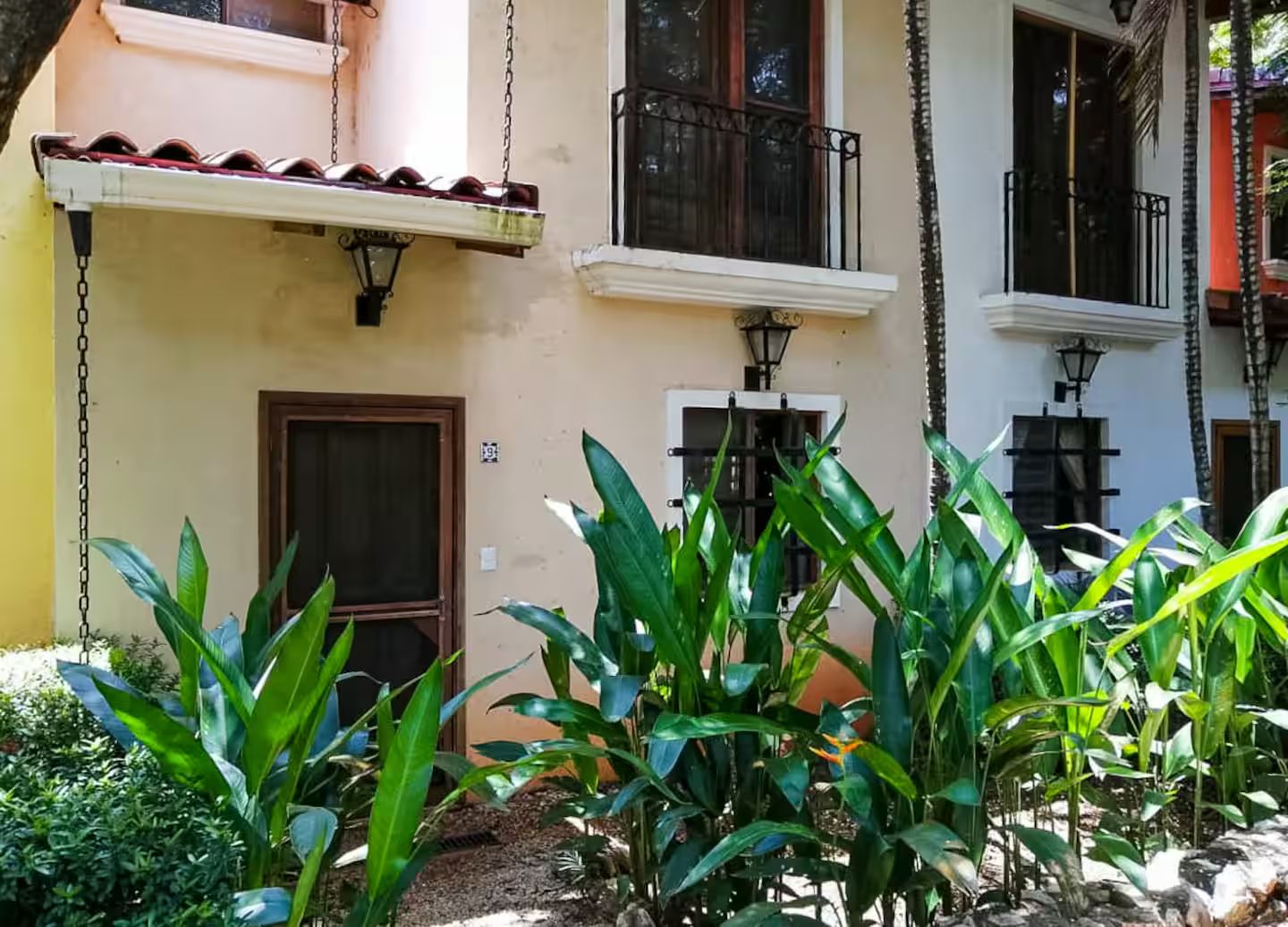 A building with a balcony, a door, and a window.