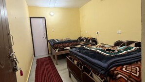 A room with two beds, a red carpet, and a door with a lock.