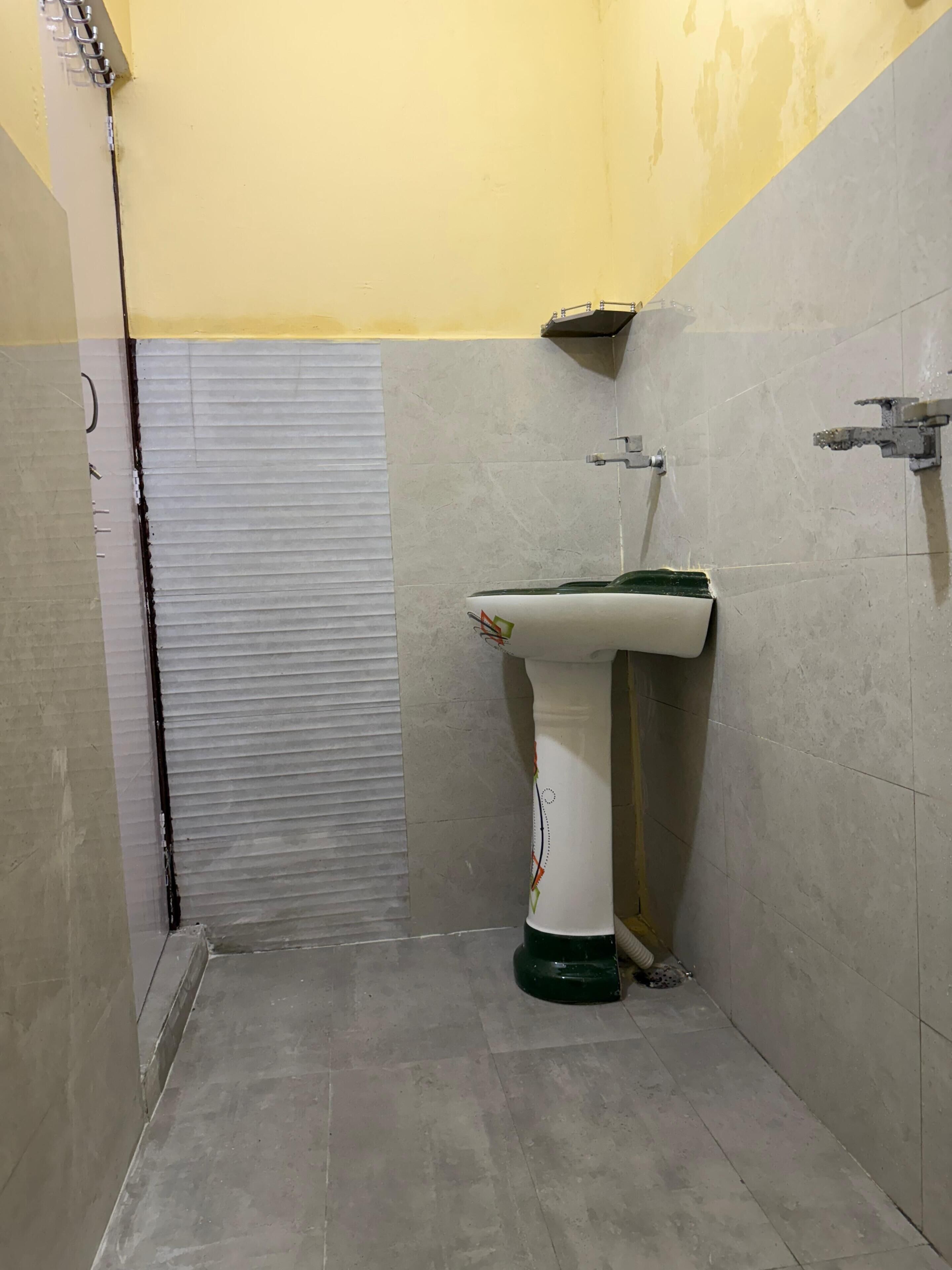 Um banheiro com vaso sanitário, pia e chuveiro.