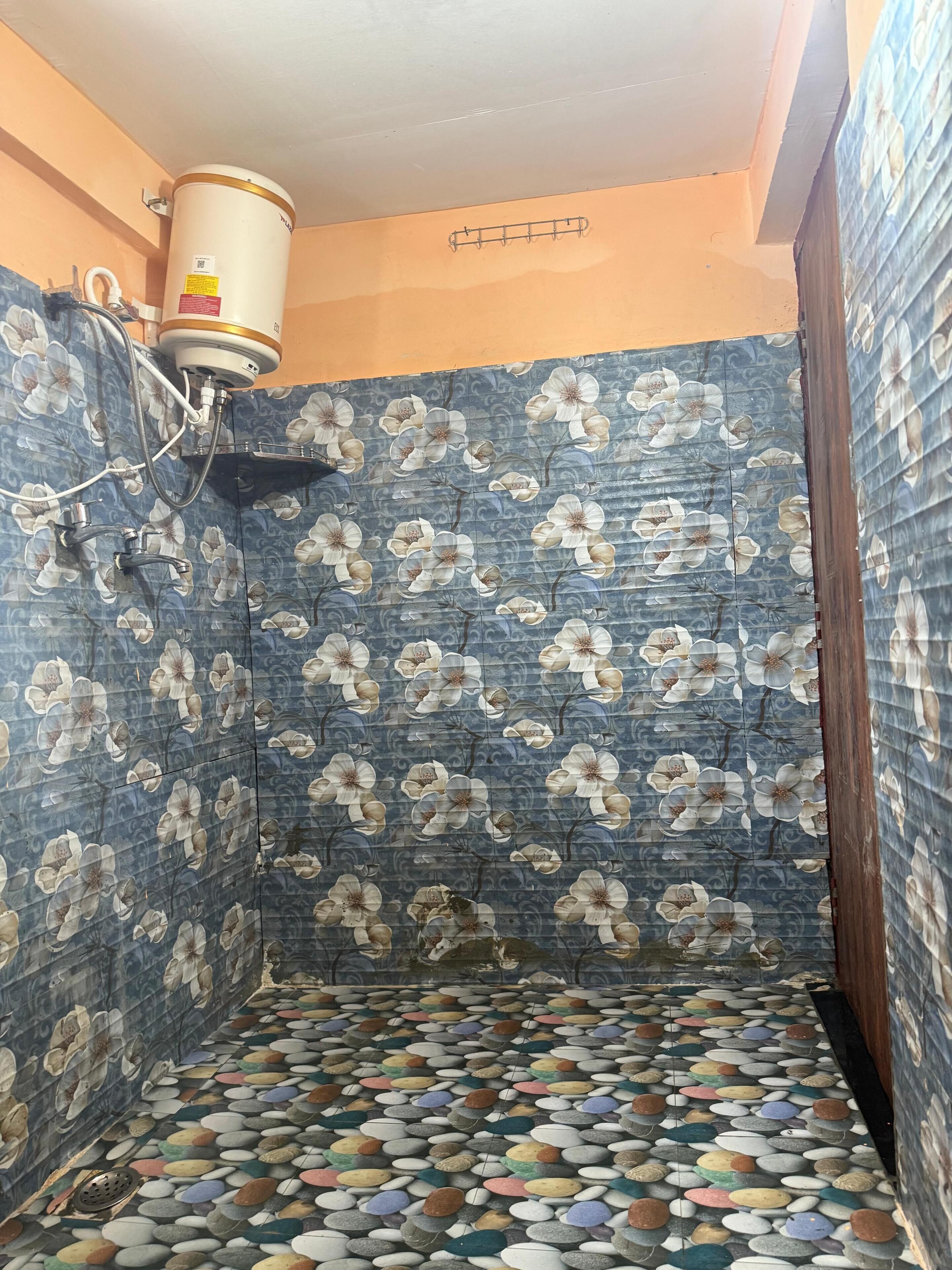 A bathroom with a tiled floor, a shower area, and a toilet.