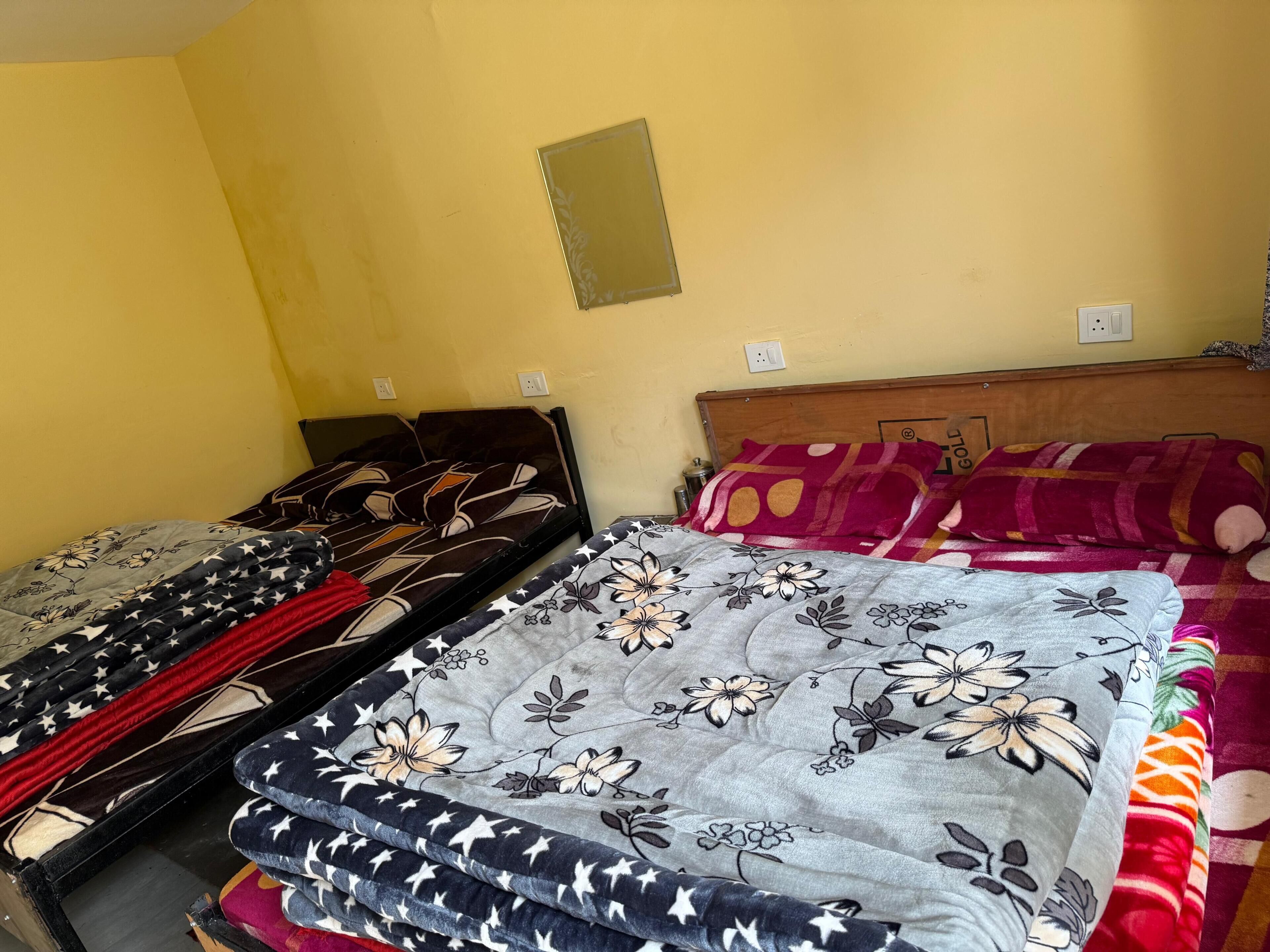 A room with two beds, each with a different patterned bedspread.