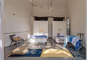 A small, compact room with a bed, a chair, and a table.