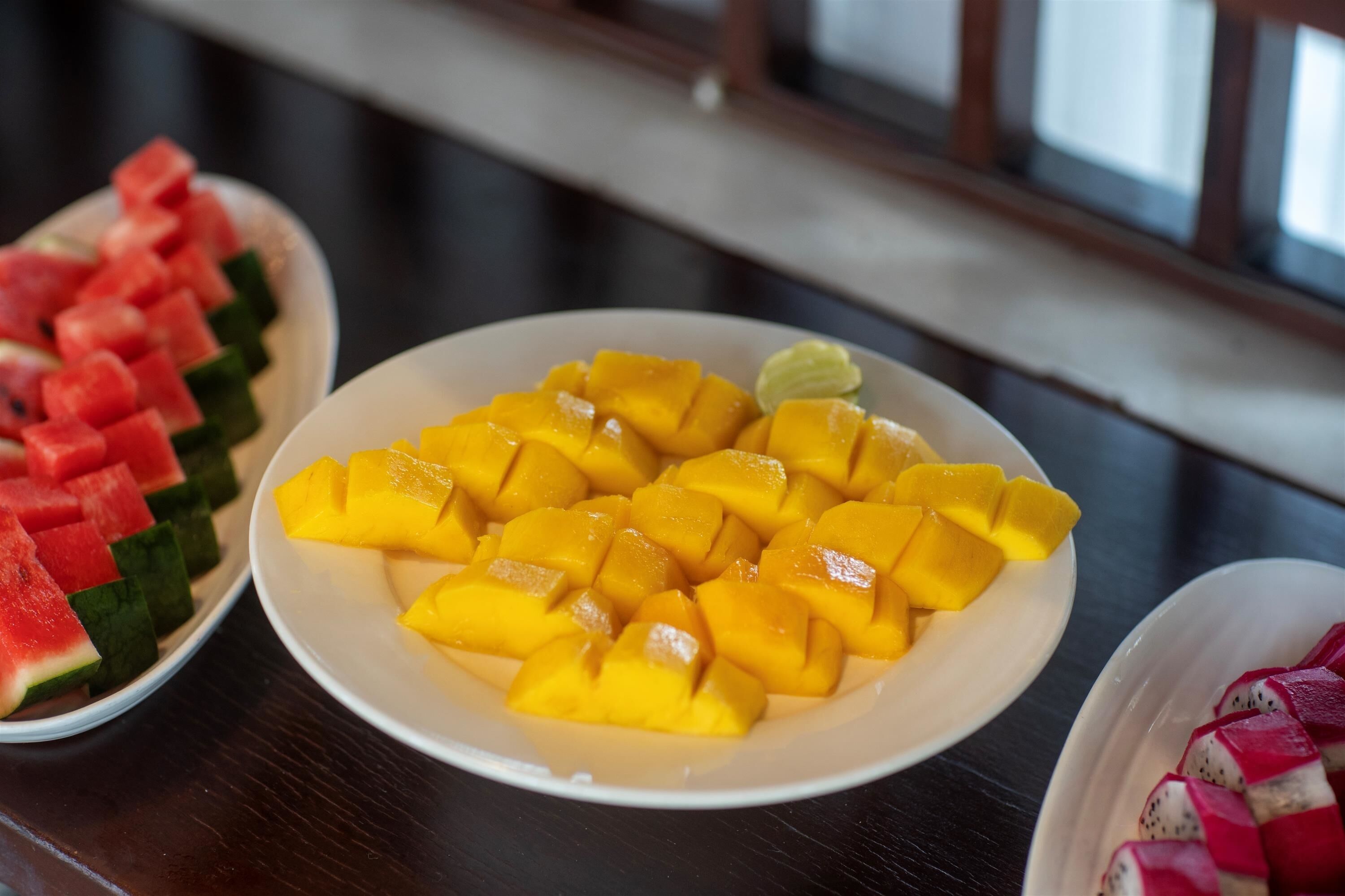 A table with plates of fruit.