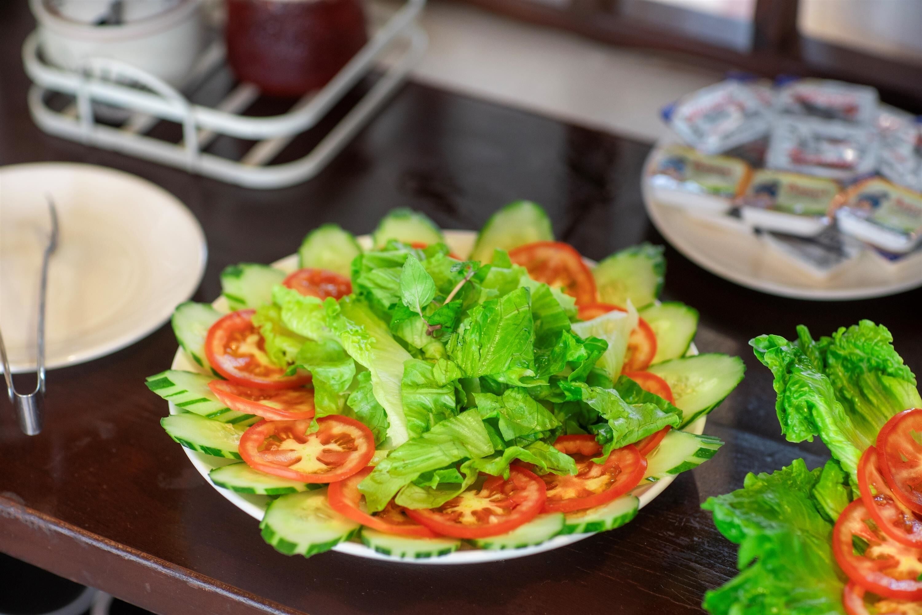 Uma salada fresca com alface, pepino e rodelas de tomate.