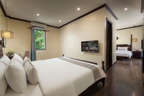 Habitación de hotel con una cama grande, televisión montada en la pared y una ventana con cortinas.