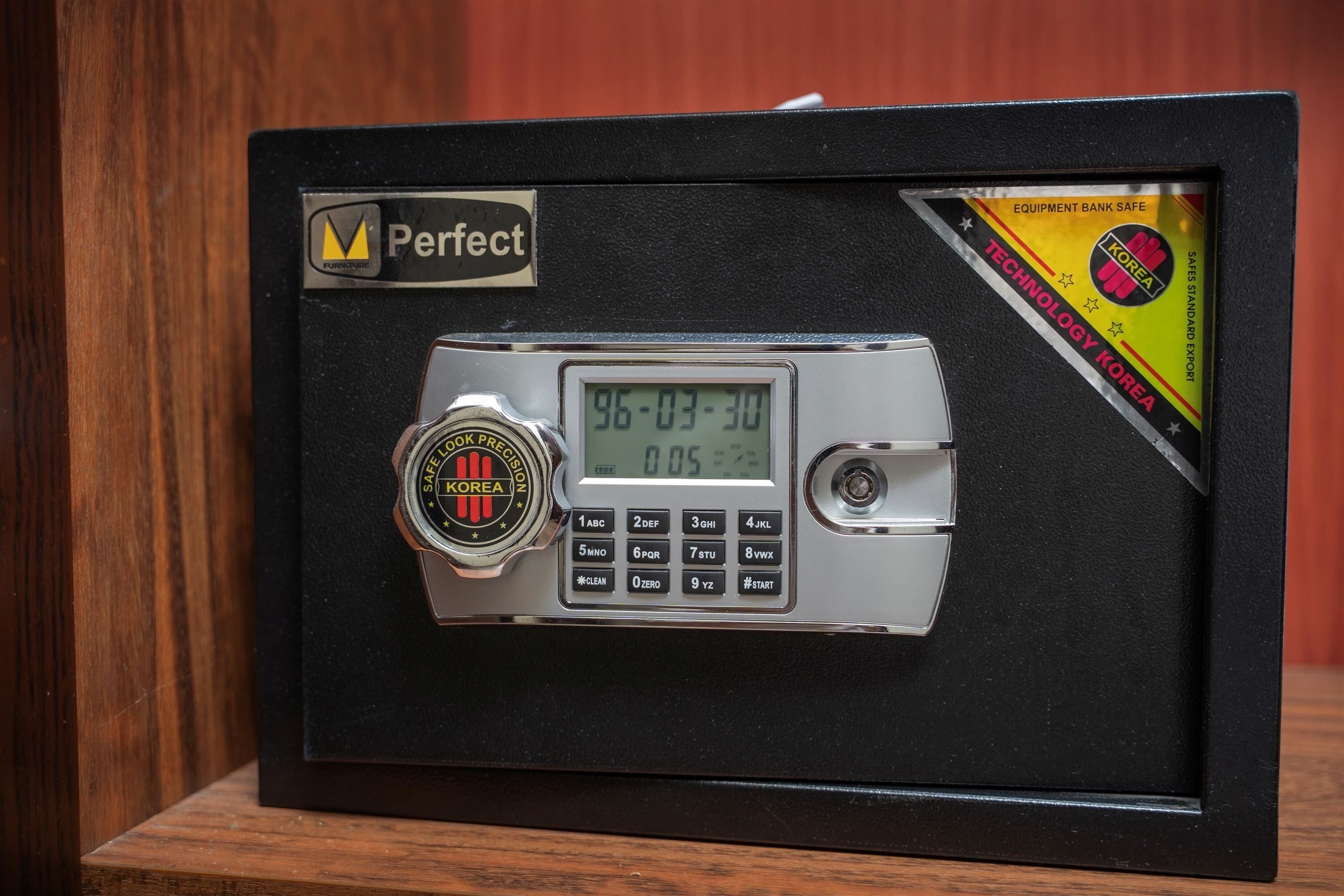 Een kluis met een digitaal keypad en een cijferschijfslot, voorzien van de labels 'Perfect' en 'KOREA'.