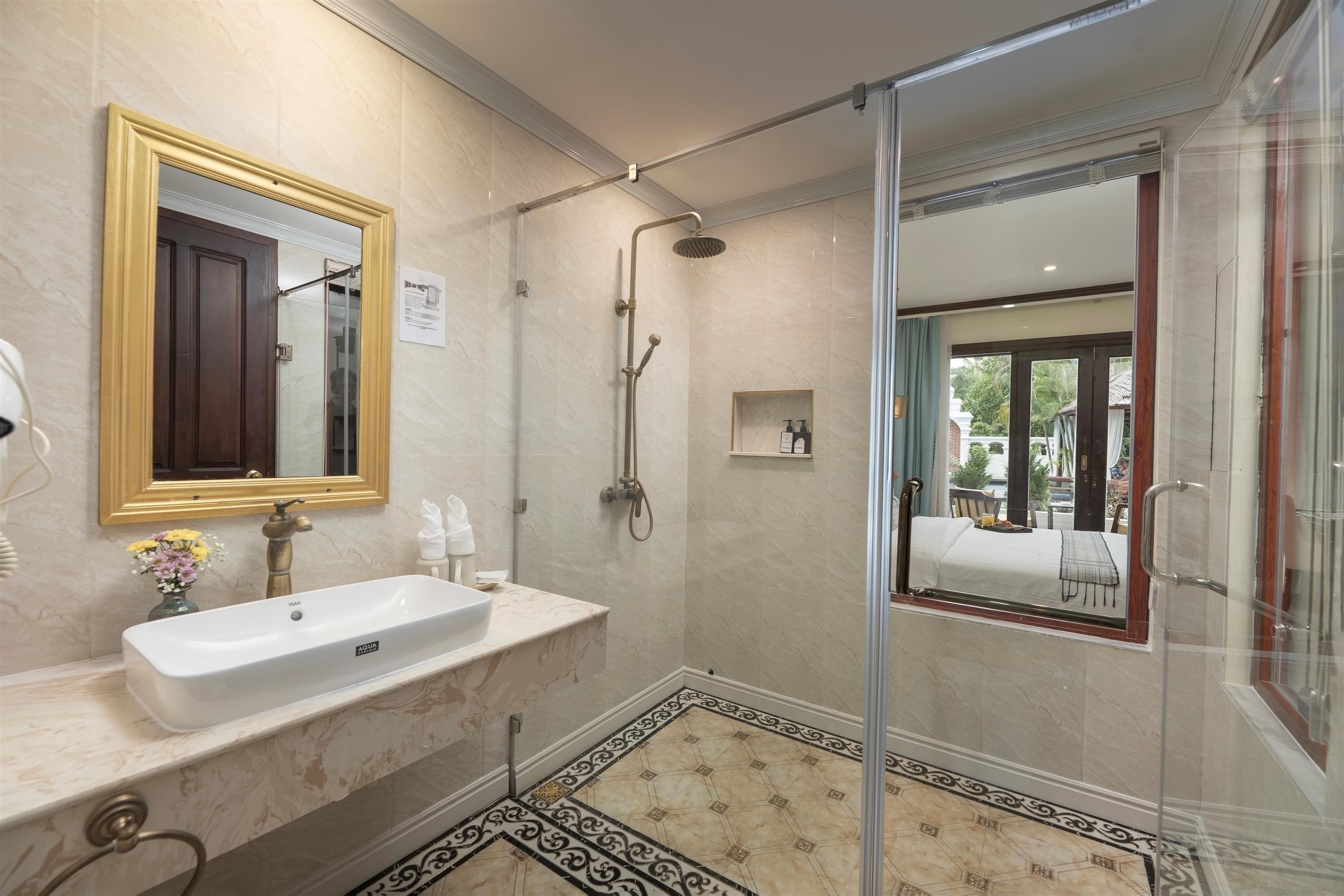 A bathroom with a white sink, a shower, and a glass-enclosed shower area.