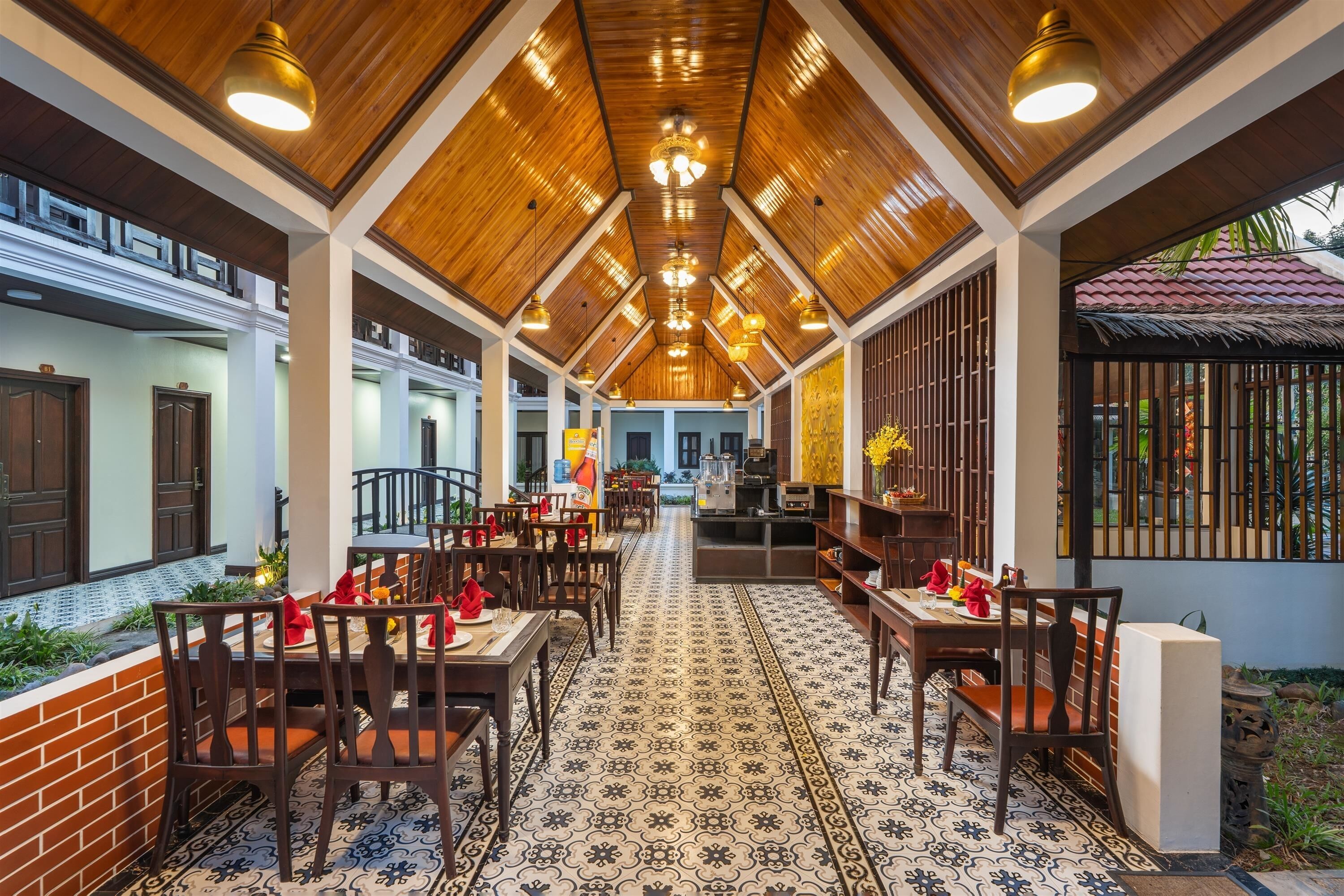 Un restaurante con techos altos, vigas de madera y baldosas de suelo con diseños.
