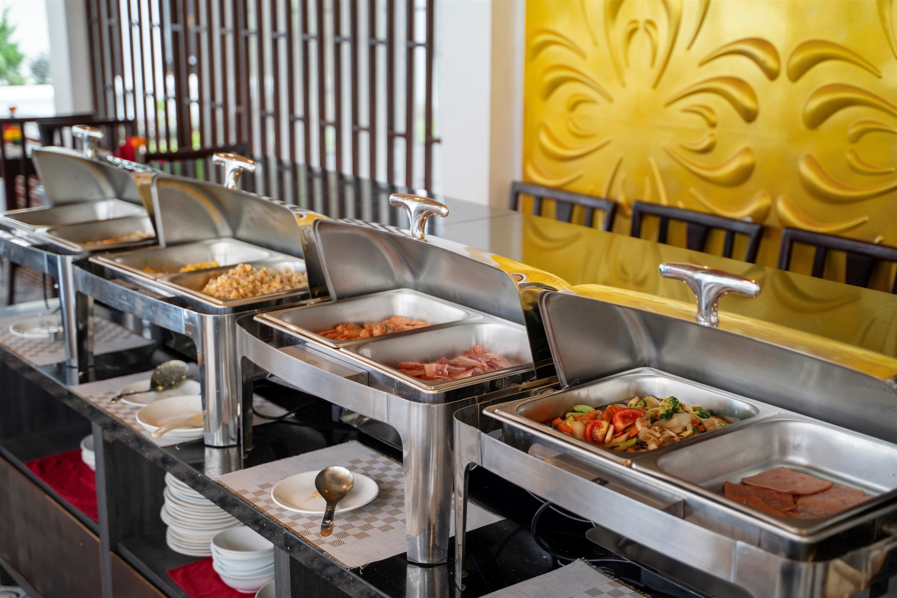 A buffet with multiple food stations, including a variety of meats and vegetables.