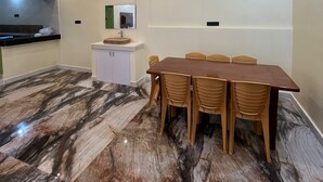 Una sala de conferencias con piso de mármol, una mesa de madera y seis sillas.