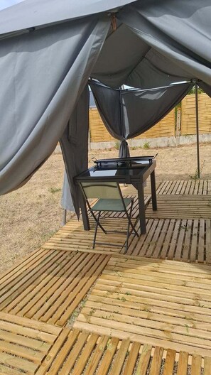 A tent with a table and chairs set up on a wooden deck. - La Tiny de Touraine – Nature & Confort (Auzouer-en-Touraine)